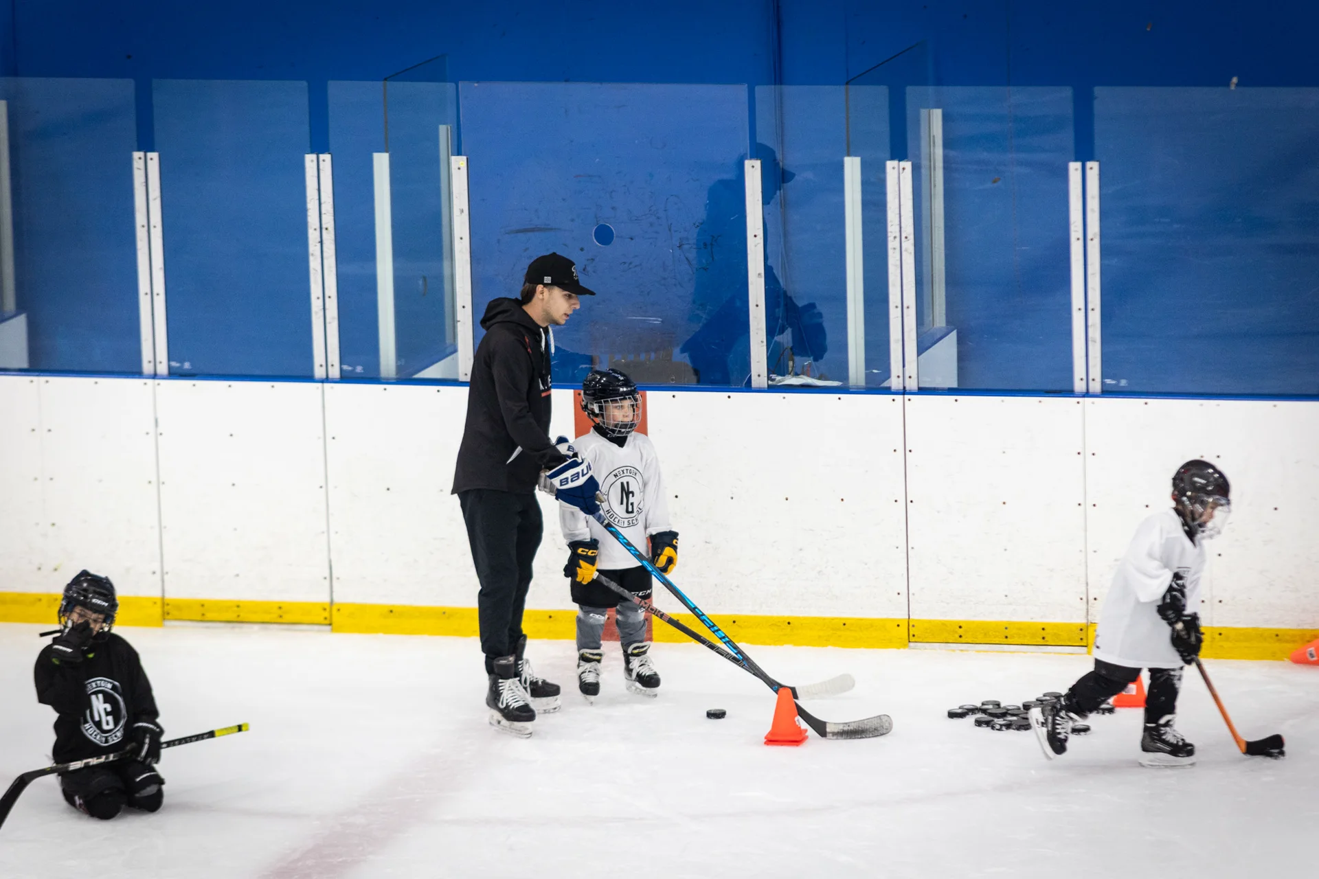 A NextGen coach running an on-ice development session with young players