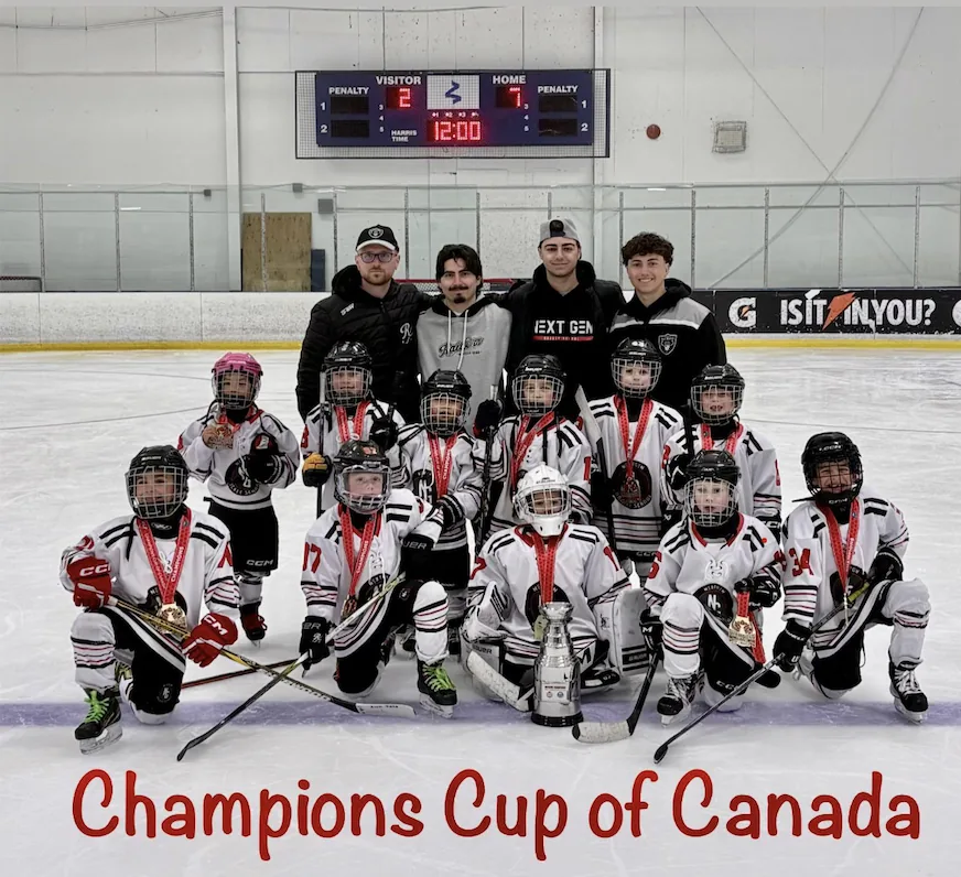 The NextGen team on the ice with their medals and the Champions Cup of Canada trophy, with their coaching staff behind them